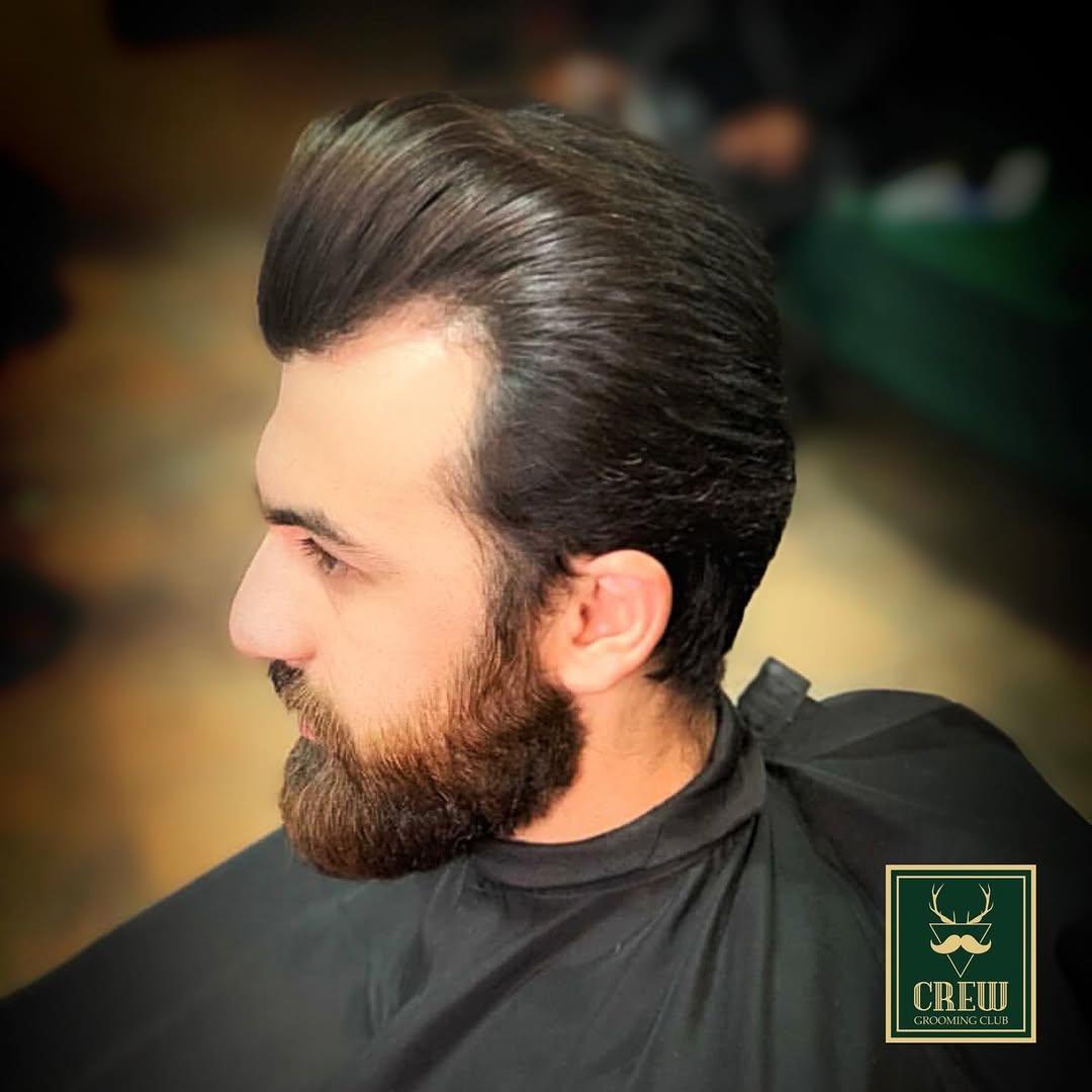Slicked-back hairstyle paired with a sculpted beard trim at Forge & Finch West London